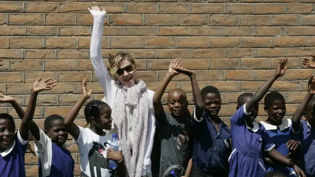 La star est impliqué dans plusieurs œuvres de bienfaisance notamment au MAlawi, pays d'origine de deux de ses enfants. Ici, devant un bâtiments d'une école reconstruit grâce à ses fonds et ceux d'une ONG américaine.