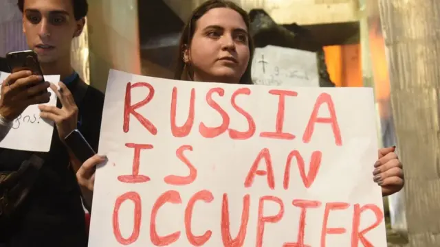 Протестующая с плакатом "Россия - оккупант"