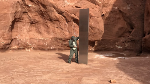 A wildlife official stands by the monolith