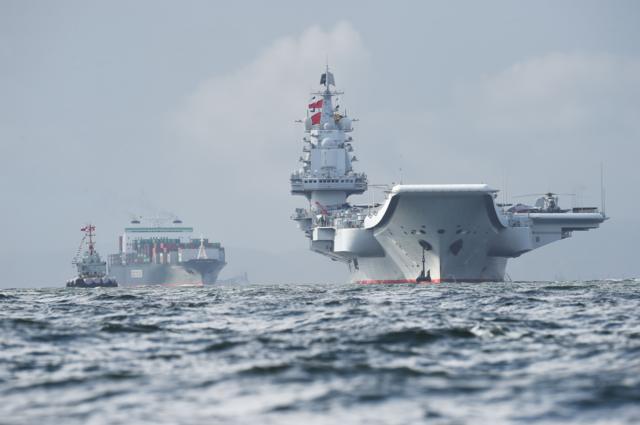 China's sole aircraft carrier, the Liaoning (R), arrives in Hong Kong waters on July 7, 2017,