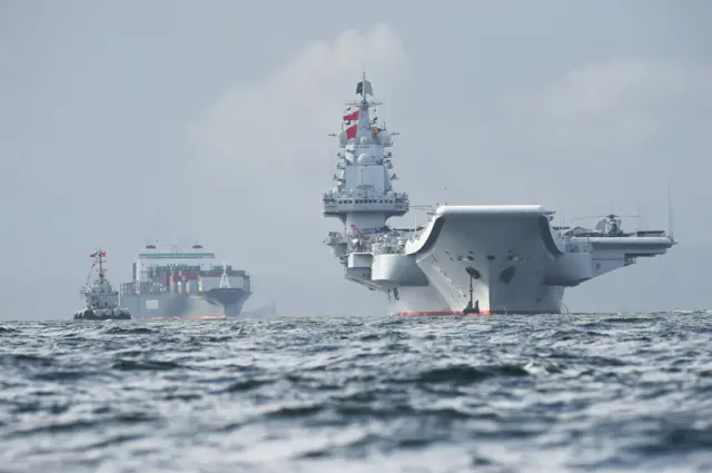 China's sole aircraft carrier, the Liaoning (R), arrives in Hong Kong waters on July 7, 2017,