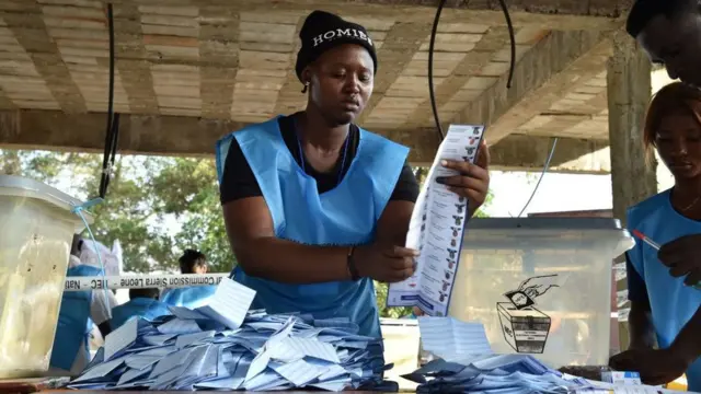 Sierra Leone election worker hold ballot paper as e dey count votes for polling station for Freetown on March 7, 2018.