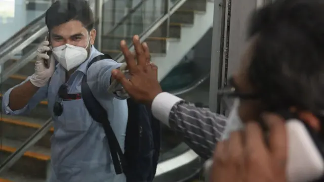 করোনাভাইরাস মহামারিতে বসে পড়েছে বিমান চলাচল খাত। কলকাতা বিমানবন্দরে আগত একজন যাত্রী স্বজনের ষ্পর্শ নিচ্ছেন।