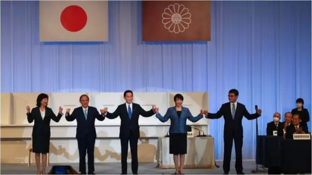 在日本东京，前外相岸田文雄（中）与即将离任的首相菅义伟（左二）及其他候选人野田圣子（左一）、高市早叶（右二）和河野太郎（右一）庆祝赢得自民党领导人选举。