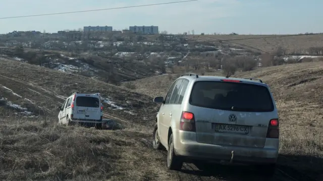 Carros atravessando campos para deixar Kharkiv