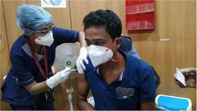 একজন স্বাস্থ্যকর্মী কোভিশিল্ডের টিকা নিচ্ছেন