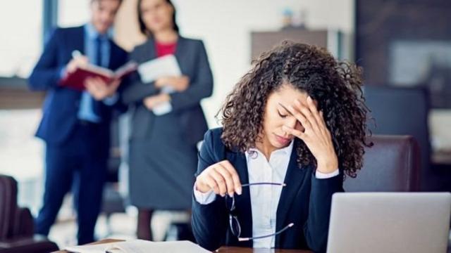 Mulher apoiando a cabeça na mão sobre mesaquero jogos de tiroescritório