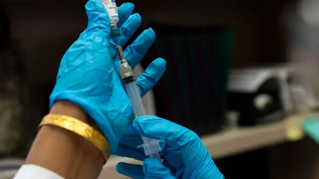 a syringe being prepared for a vaccination