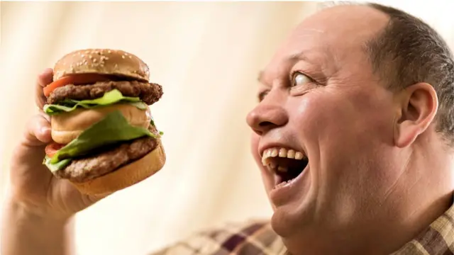 homem comendo burger