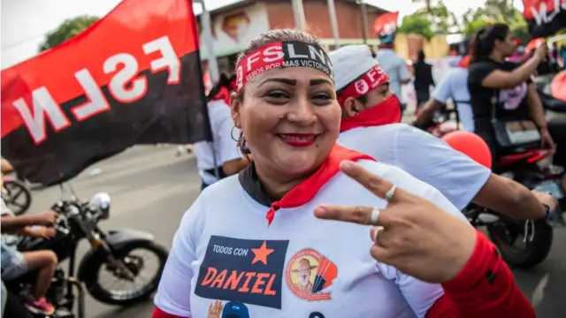 Mulher com faixa do FSLN e camisetabrabetbrabet em manutençãomanutençãoDaniel Ortega