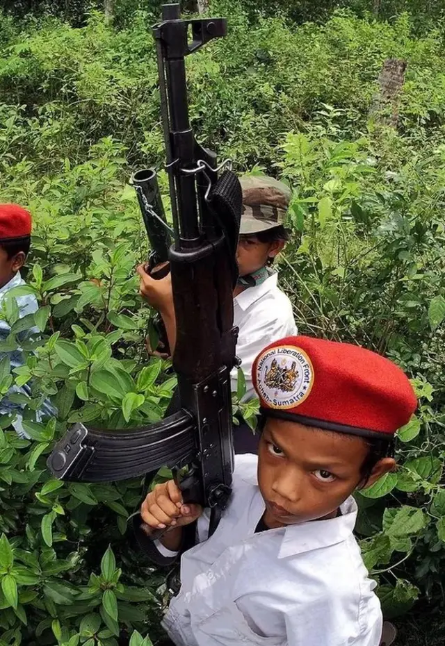 Seorang anak di wilayah Pidie, Aceh, terlibat latihan militer dengan membawa senjata laras panjang AK-47, 20 November 2009.
