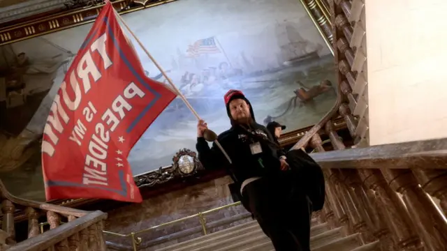 Un amotinado dentro del Capitolio de Estados Unidos ondea una bandera que dice "Trump es mi presidente" el pasado 6 de enero de 2021.