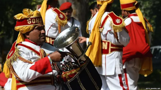 Indian members of a brass band waits on the road prior to performing at a wedding in New Delhi on January 28, 2018.