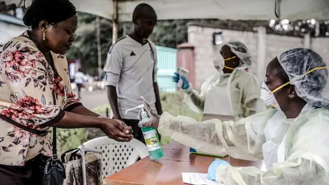 Maafisa wa afya wakiwasafisha watu mikono na kuwapima virusi vya corona