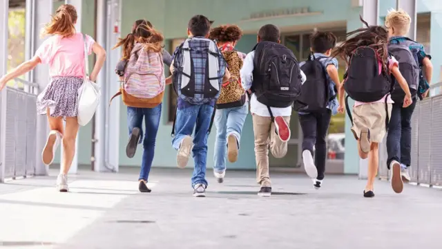 Niños corriendo en una escuela.