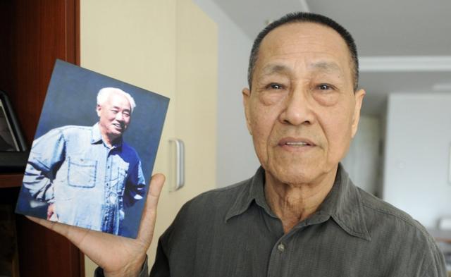 Bao Tong, a former senior government official who was jailed for opposing the 1989 Tiananmen Square crackdown, shows a photo of his former boss former Zhao Ziyang, a leading reformer and secretary-general of the Chinese Communist Party, who was toppled in 1989, after trying to find common ground with the student demonstrators in Tiananmen Square, during an interview with AFP at his home in Beijing on February 22, 2011.