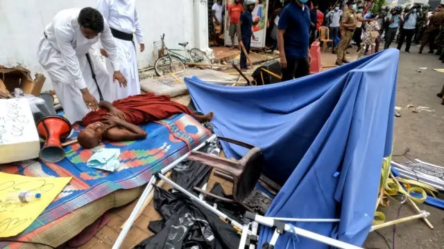 நேற்று (மே 9) எடுக்கப்பட்ட படம் இது. அரசுக்கு எதிராக போராடிய புத்த துறவி காயமடைந்த நிலையில், அவருக்கு கத்தோலிக்க பாதிரியார்கள் உதவி செய்கின்றனர்