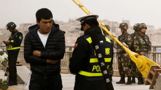 Поліцейський перевіряє паспорт в уйгура