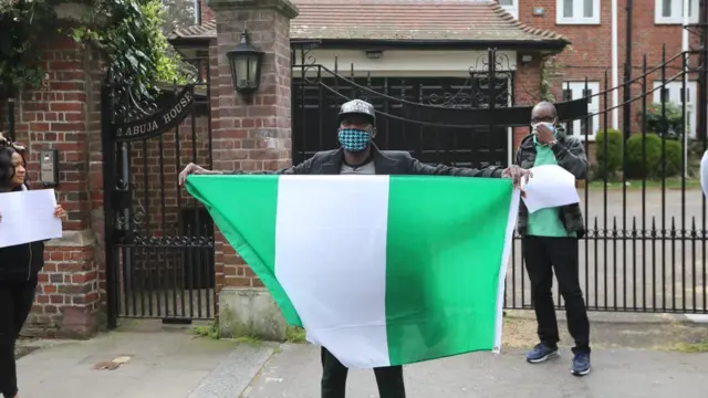 Fmr presidential aide, Reno Omokri dey carry di Nigeria flag in front of Abuja House for UK