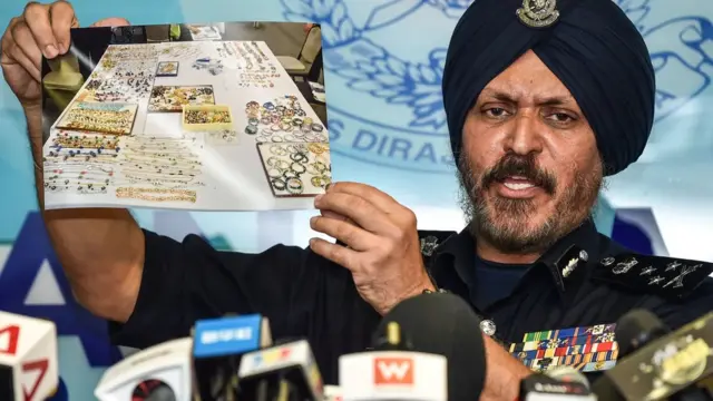 Polisi Amar Singh menunjukkan foto hasil sitaan di kediaman Najib Razak.