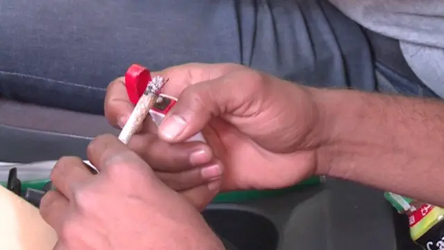 شخص يشعل سيجارة