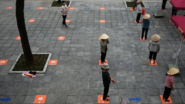 Người nghèo ở Hà Nội xếp hàng chờ nhận gạo miễn phí trong thời gian cách ly xã hội ở Việt Nam.
