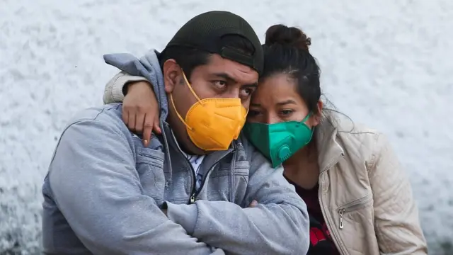 Un hombre y una mujer abrazados esperan noticias de sus familiares