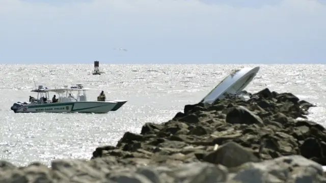Embarcación volcada sobre una escollera.