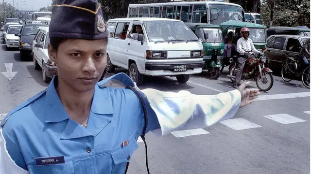 ঢাকায় গাড়ি-চলাচল নিয়ন্ত্রণ করছেন একজন নারী পুলিশ কর্মী।
