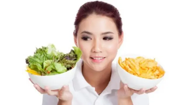 فتاة تحمل طبقين من الفواكه والخضروات