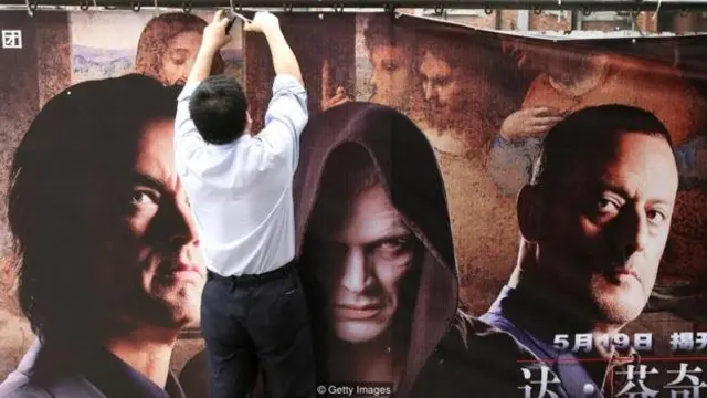 مردی در حال نصب کاغذ تبلیغ فیلم