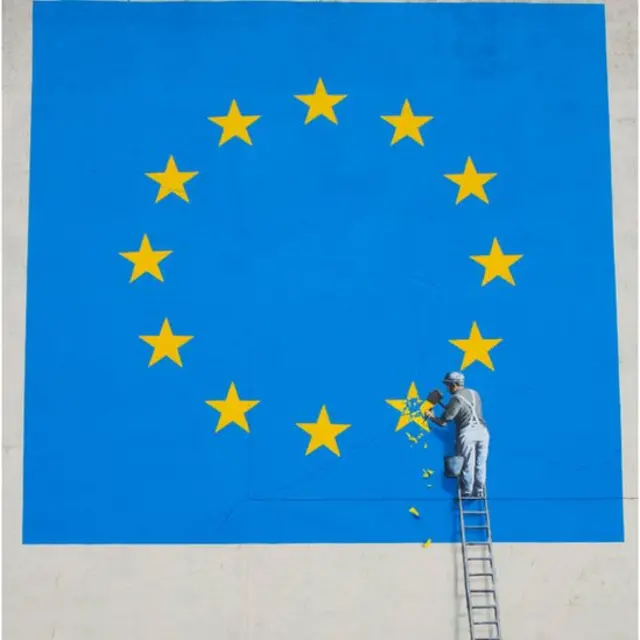 งานศิลปะของแบงก์ซี ศิลปินที่มีงานบนกำแพงสาธารณะที่โด่งดังของอังกฤษ ทำเป็นคนกำลังเอาดาวออกจากธงของอียู ซึ่งแทนความหมายว่าอังกฤษกับจะออกจากอียู หรือ เบรกซิท งานชิ้นนี้อยู่บนกำแพงที่ท่าเรือโดเวอร์ของอังกฤษ