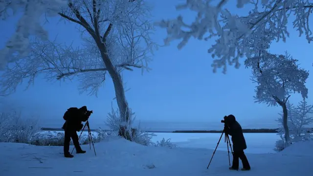 عکاسان د اوبو څنډو کې د ښکلې منظرې عکاسۍ کوي.