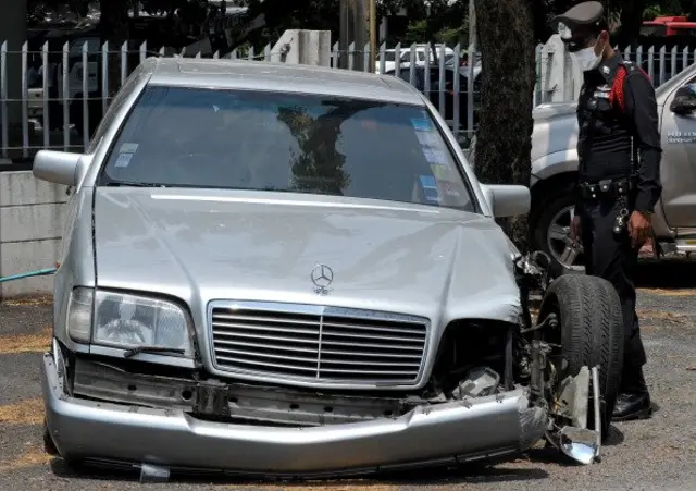 เจ้าหน้าที่ตำรวจยืนสำรวจซากรถที่ประสบอุบัติเหตุ