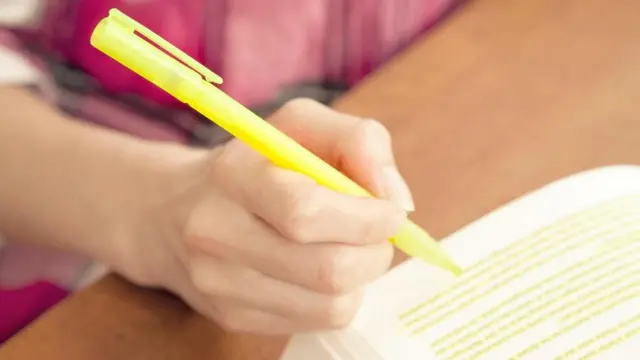 طالب يظلل بقلمه بعض أسطر الكتاب