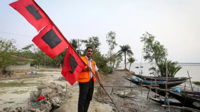 رضاکار جھنڈوں کے نظام کے ذریعے طوفان کی شدت سے لوگوں کو آگاہ کرتے ہیں