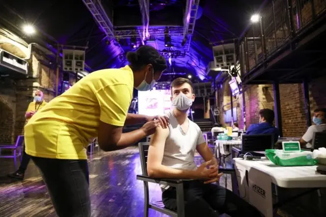 A person receives a dose of the Pfizer BioNTech vaccine at an NHS vaccination centre hosted at the Heaven nightclub, amid the coronavirus disease (COVID-19) pandemic, in London, Britain, August 8, 2021.
