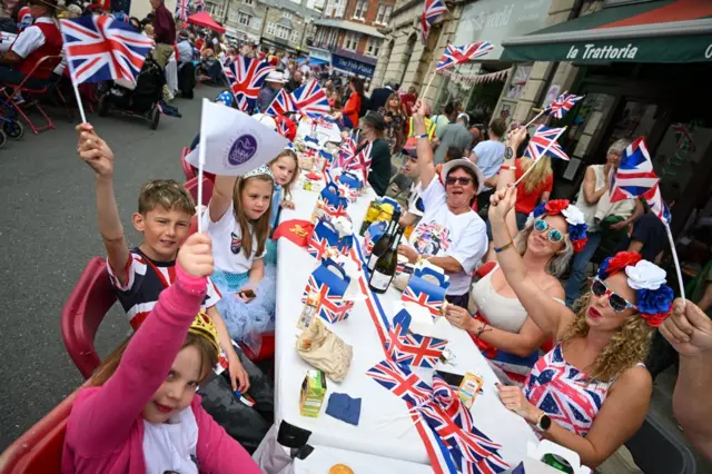 Participants wave flags during the town's street party on 3 June 2022 in Swanage, Dorset