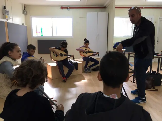 इसराइल के एक स्कूल में संगीत की कक्षा में शांति के गीत गाते बच्चे