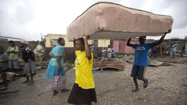Residentes de Les Cayes trasladan un colchón a un refugio.