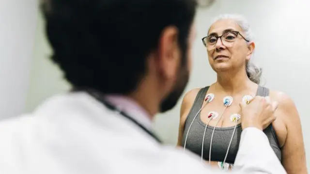 Mulher se preparando para exame cardiológico