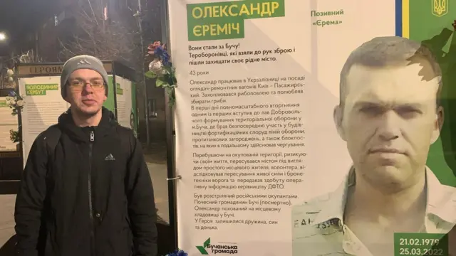 Сергій Єреміч біля меморіального банера у пам’ять про його батька - Олександра Єреміча розстріляли росіяни три роки тому, за кілька днів до звільнення Бучі
 675