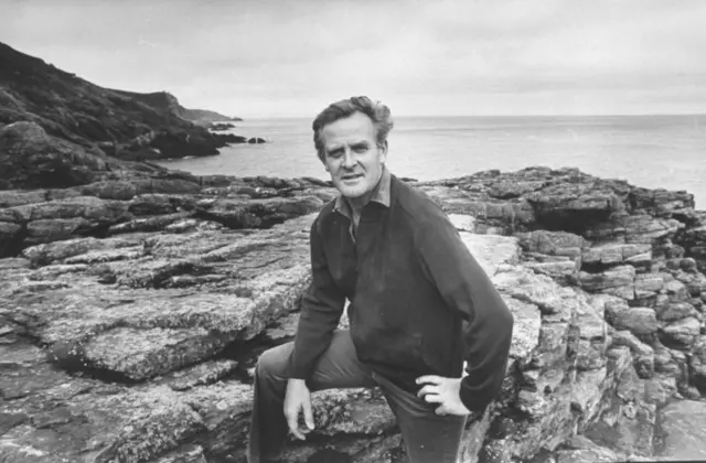 John le Carré Cornwall'daki evinin yakınındaki kayalıklarda oturuyor (Ağustos 1974) (Photo by Ben Martin/Getty Images)