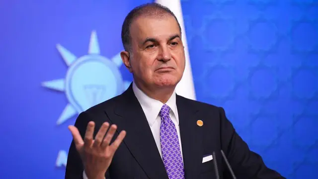 Ömer Çelik açıklama yapıyor. Arkasındaki duvarda AKP logosu gözüküyor. 