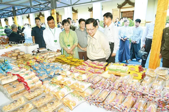 မေလတုန်းက မန္တလေးတိုင်း MSME လုပ်ငန်းရှင်တွေနဲ့ ဦးမင်းအောင်လှိုင်တွေ့ဆုံတဲ့ ပွဲမှာ ခင်းကျင်းပြသထားတဲ့ ပစ္စည်းတွေကိုလိုက်ကြည့်နေတဲ့ မြင်ကွင်း 