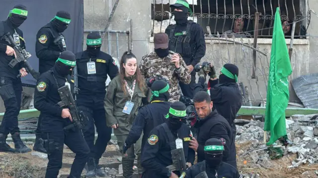 Bir İsrailli kadın asker, yüzü maskeli Hamas askerlerinin arasında ilerliyor