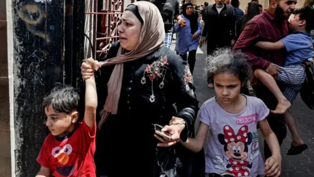 গাজায় ইসরায়েলি বিমান হামলা শুরুর পর একটি ভবন থেকে পালানোর চেষ্টা করছে বাসিন্দরা