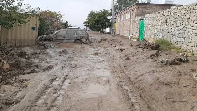 A car is left standing in mud following the flash floods