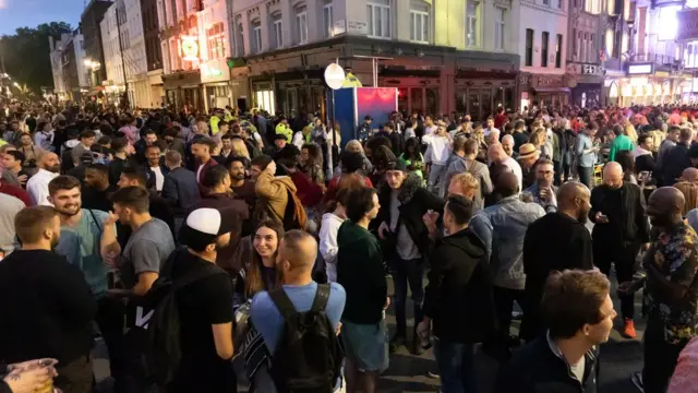 Pessoas bebem na rua no Soho,pix bettLondres