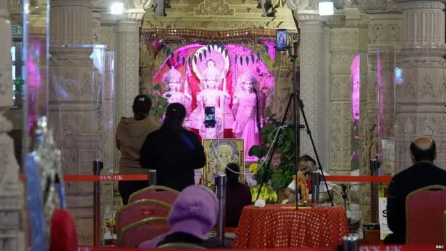ब्रिटेन के मंदिर में पूजा करते लोग